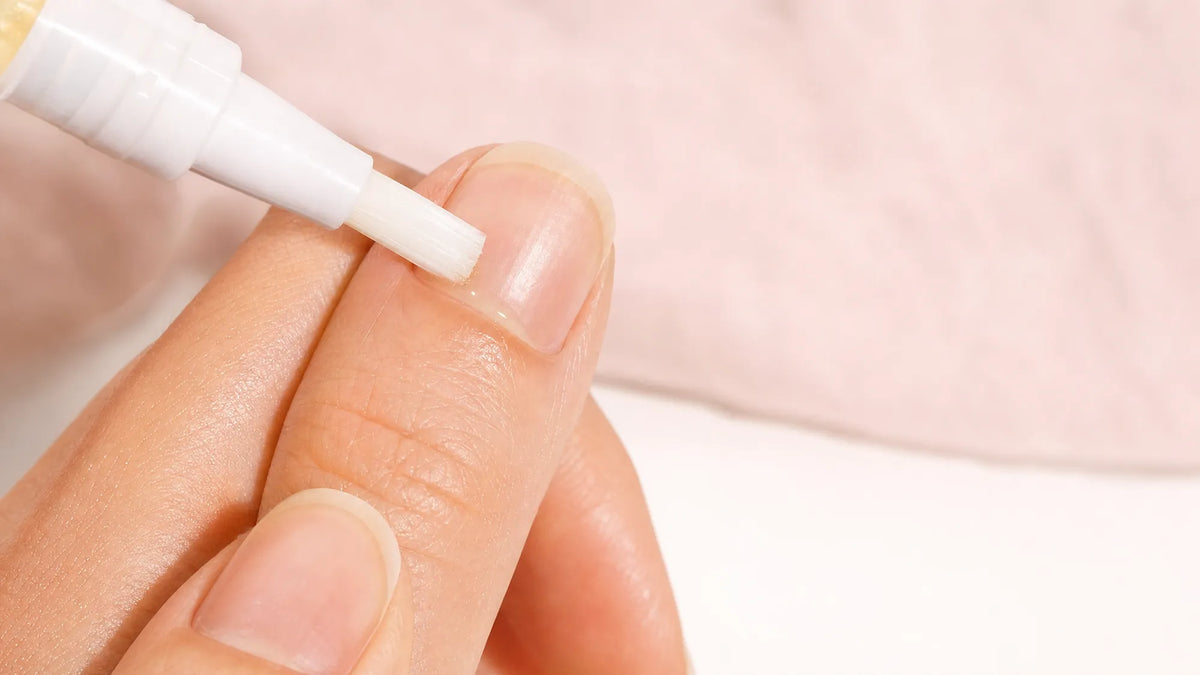 Applying nail serum to the cuticle of a long natural nail