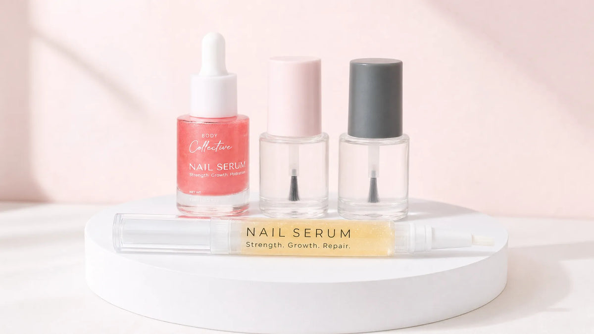 Cuticle oil pen, nail serum dropper, strengthener and hardener bottles lined up on a white podium