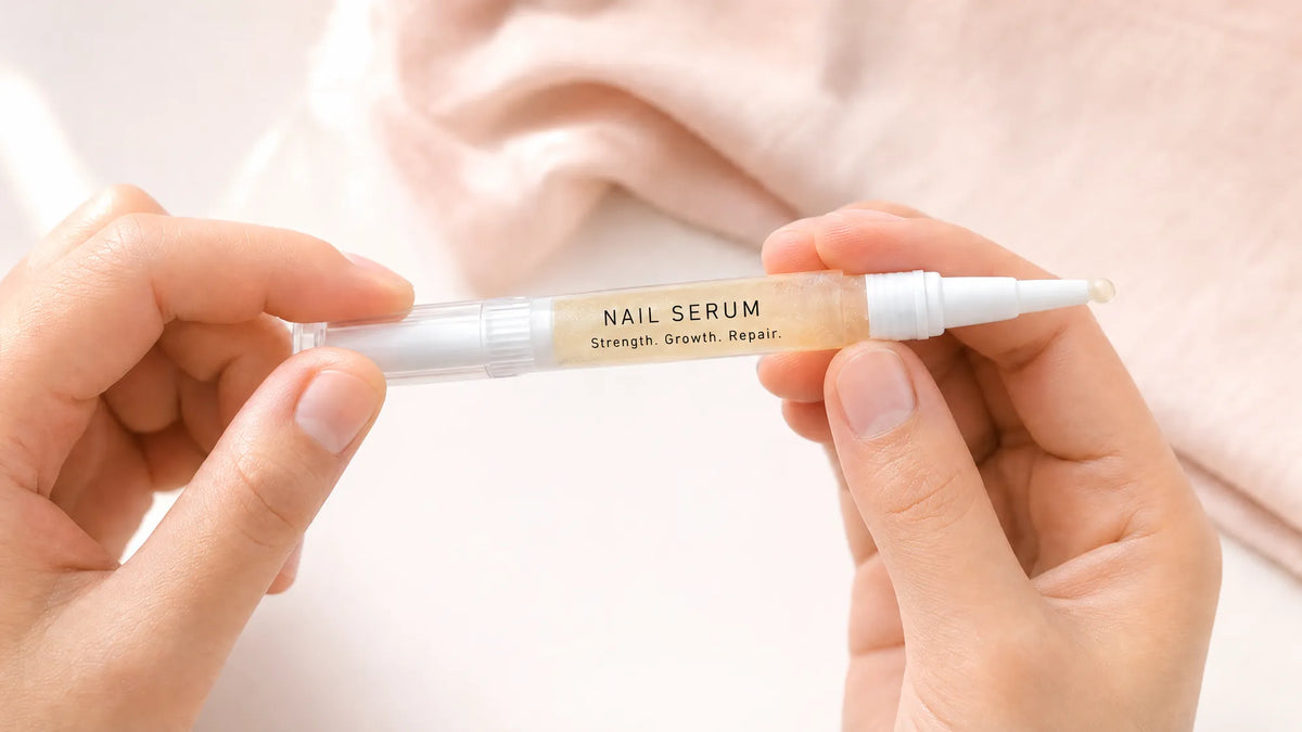 Twisting the base of a Body Collective cuticle oil pen until serum reaches the brush